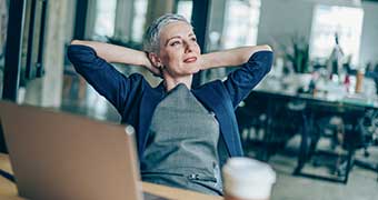 Women leaning back in office chair smiling