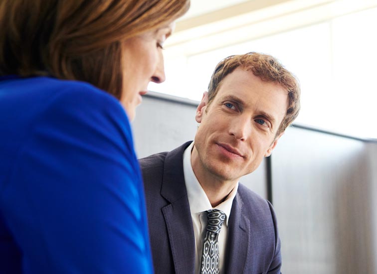 Un homme discute avec une femme dans un bureau.