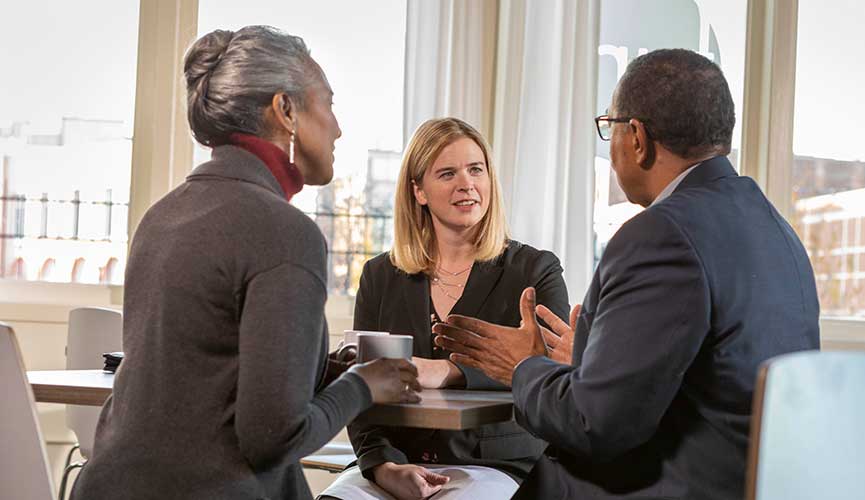 Woman conversing with couple over coffee