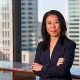 Business woman standing confidently in front of metro business window